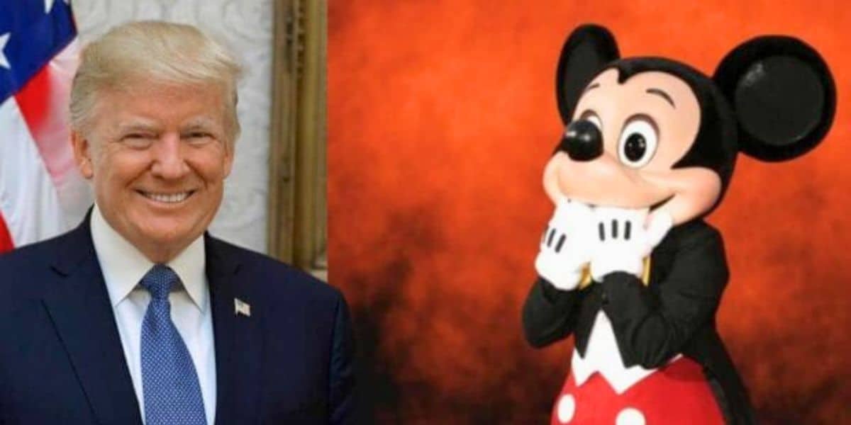 A man in a suit and tie, smiling with an American flag partially visible behind him on the left, is next to a large costumed character resembling Mickey Mouse, who has a surprised expression and is standing against an orange background on the right. This moment quickly caught the attention of news media outlets.
