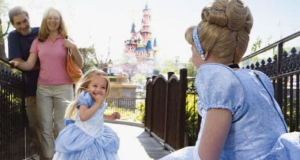 A young girl in a Cinderella dress runs up to greet Cinderella in Disneyland Paris