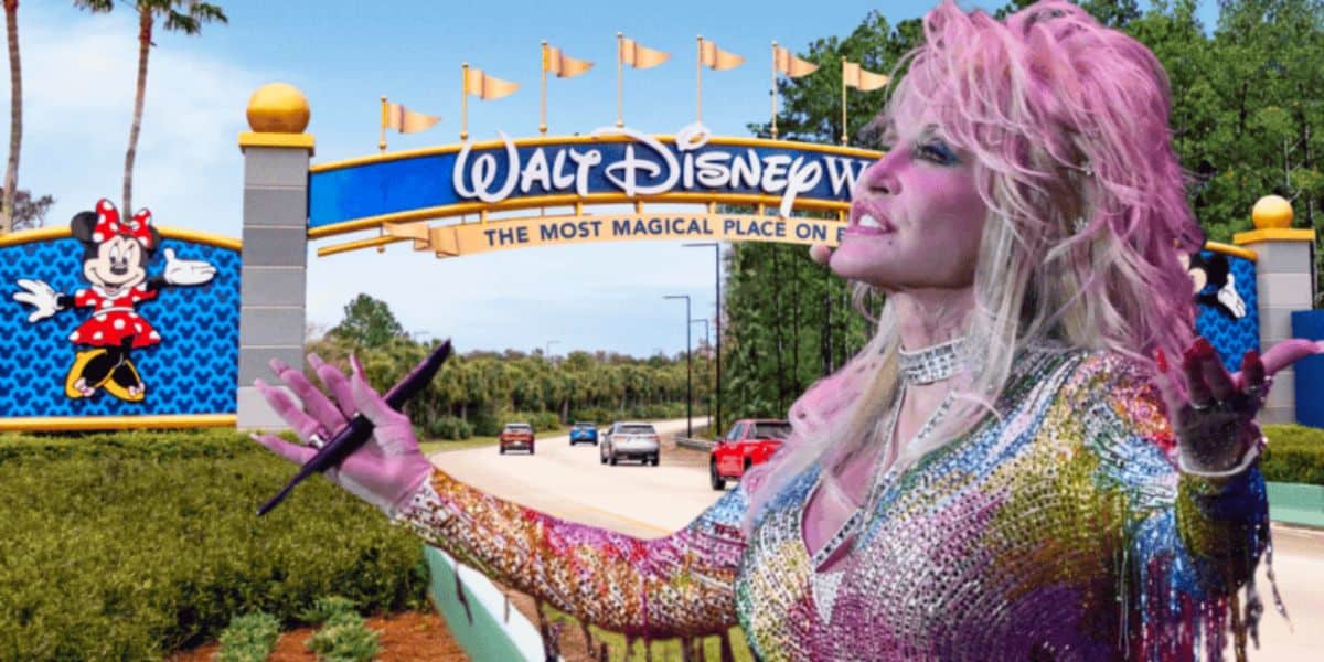 A vibrant figure with blonde hair and a colorful outfit stands in front of the entrance arch to Walt Disney World, which features the park's name and slogan, "The Most Magical Place on Earth." The road beneath the arch is lined with greenery, and cars are visible.
