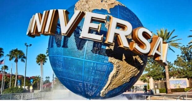 Rotating globe with the Universal Studios logo, under a clear blue sky, welcoming visitors to an adventurous theme park experience.