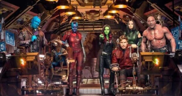 A group of seven diverse characters in a futuristic setting. They stand and sit in a spaceship, dressed in various colorful outfits. The background is filled with advanced technology and control panels.