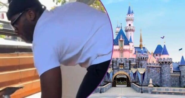 A person lifting a table, Sleeping Beauty Castle at Disneyland.