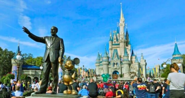 Guests look on inside the Magic Kingdom besides the Walt Disney and Mickey Mouse statue, Partners, at Walt Disney World Resort