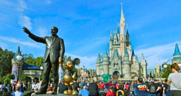 Guests look on inside the Magic Kingdom besides the Walt Disney and Mickey Mouse statue, Partners, at Walt Disney World Resort