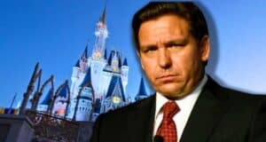 Florida Governor Ron DeSantis looking sad in front of the Cinderella Castle at Disney World.