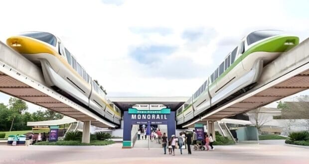 A scene with two monorail trains—one yellow and one green—passing by on elevated tracks at Disney Transportation and Ticket Center. Below, several people are entering the entrance marked "MONORAIL." Some trees and signage are visible around the area, with a partly cloudy sky above.