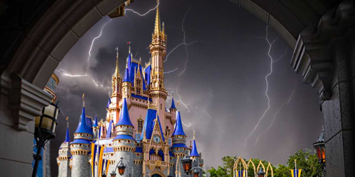 A majestic castle with blue and gold accents stands under a stormy sky with multiple lightning bolts, reminiscent of Disney World's enchanting allure. The scene, framed by a stone archway, creates a dramatic contrast between the vibrant castle and the dark, hurricane-like turbulent sky.