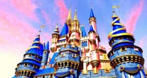 A vibrant castle with blue and gold turrets set against a pink and blue sky. The structure features intricate detailing and a fairytale-like appearance, creating a magical atmosphere.