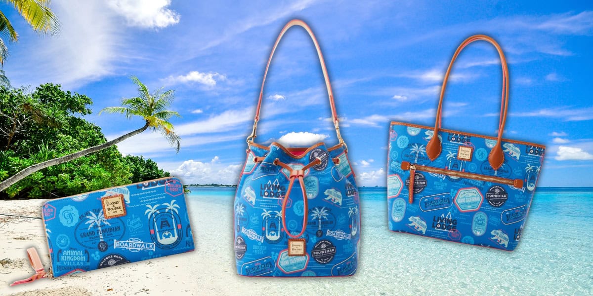 Blue handbags and a wallet with travel-themed prints are displayed on a sandy beach with clear blue water and palm trees. The sunny sky in the background adds a tropical vibe to the scene.