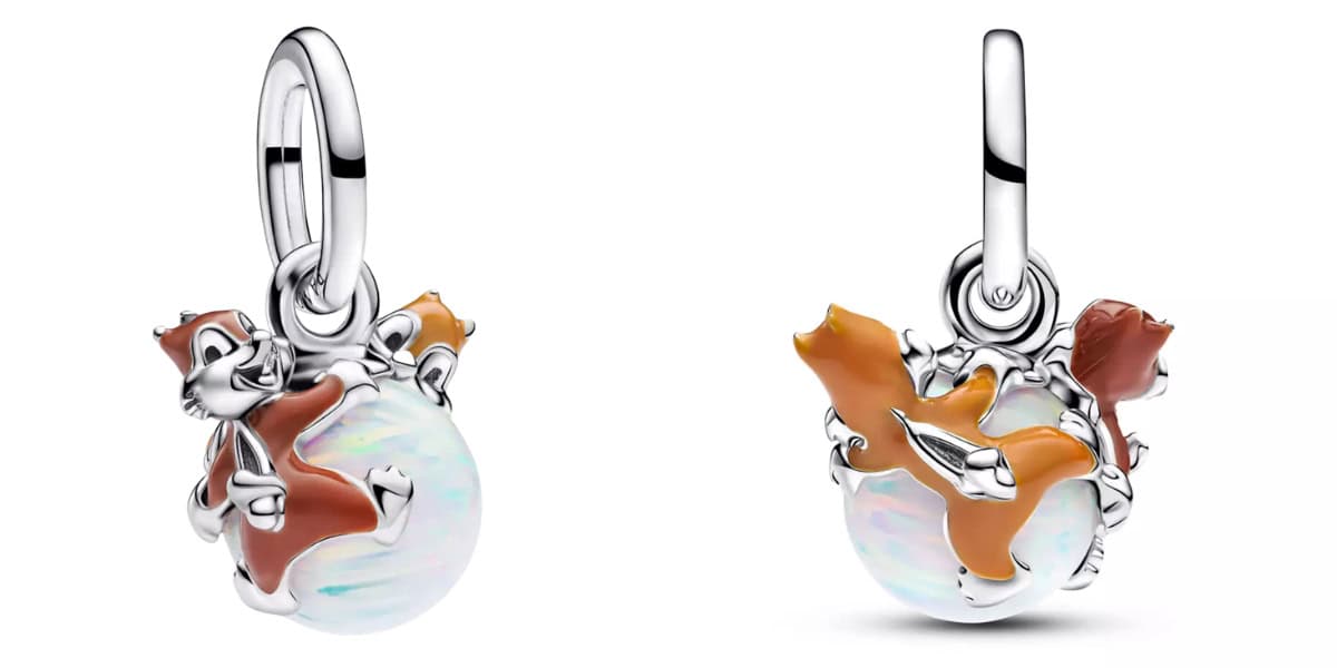 Two silver charms featuring orange and brown stylized foxes curled around opalescent spheres, highlighting intricate details and playful poses. The design emphasizes a harmonious blend of natural themes and elegant jewelry craftsmanship.