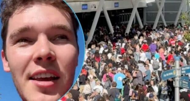 A close-up of a young man's face is on the left, with a large, bustling crowd outside a building on the right. The sky is clear, and sunlight brightens the scene.