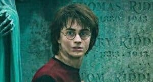 Harry Potter stares ahead in fear in front of a tombstone