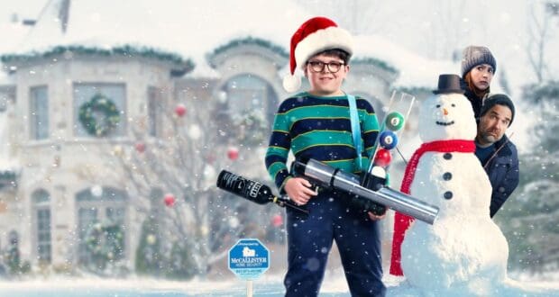 Max Mercer (Archie Yates) with a toy gun while wearing a Santa hat in the snow in the poster for 'Home Alone'