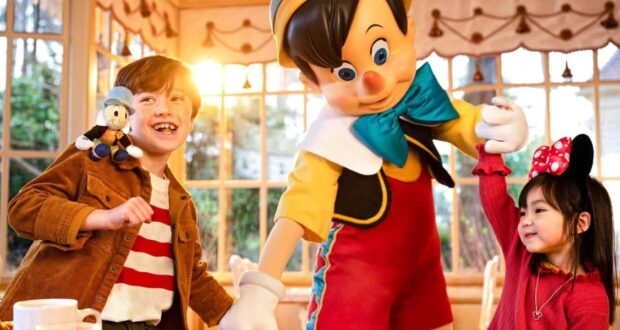Disneyland Paris guests with a Disney cast member dressed as Pinocchio at restaurant