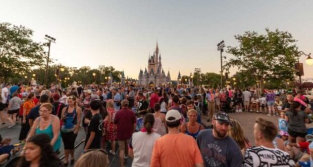 A large crowd in Magic Kingdom with Cinderella Castle in the background