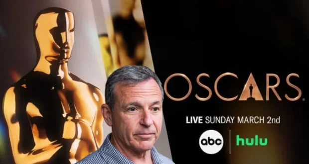 A man stands in front of an Oscars backdrop featuring a golden statuette and event details. The text reads "Oscars Live Sunday March 2nd" with ABC and Hulu logos.