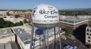 A large water tower with the Walt Disney Company logo on it stands amidst office buildings under a clear blue sky. A Disney employee recently suffered a hack after downloading an AI software.