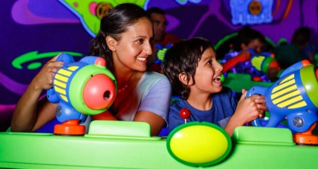 A woman and a child ride Buzz Lightyear's Space Ranger Spin