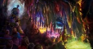 A group of people rides a train through a colorful, glowing cave filled with vibrant stalactites and stalagmites, illuminated by multicolored lights and reflections in luminous pools of water.