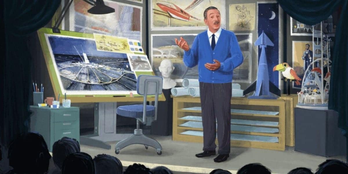 An animated man in a blue sweater speaks to an audience, standing in a studio with sketches, models of futuristic buildings, a rocket, and a bird model behind him. A large drawing desk and art supplies are also visible.