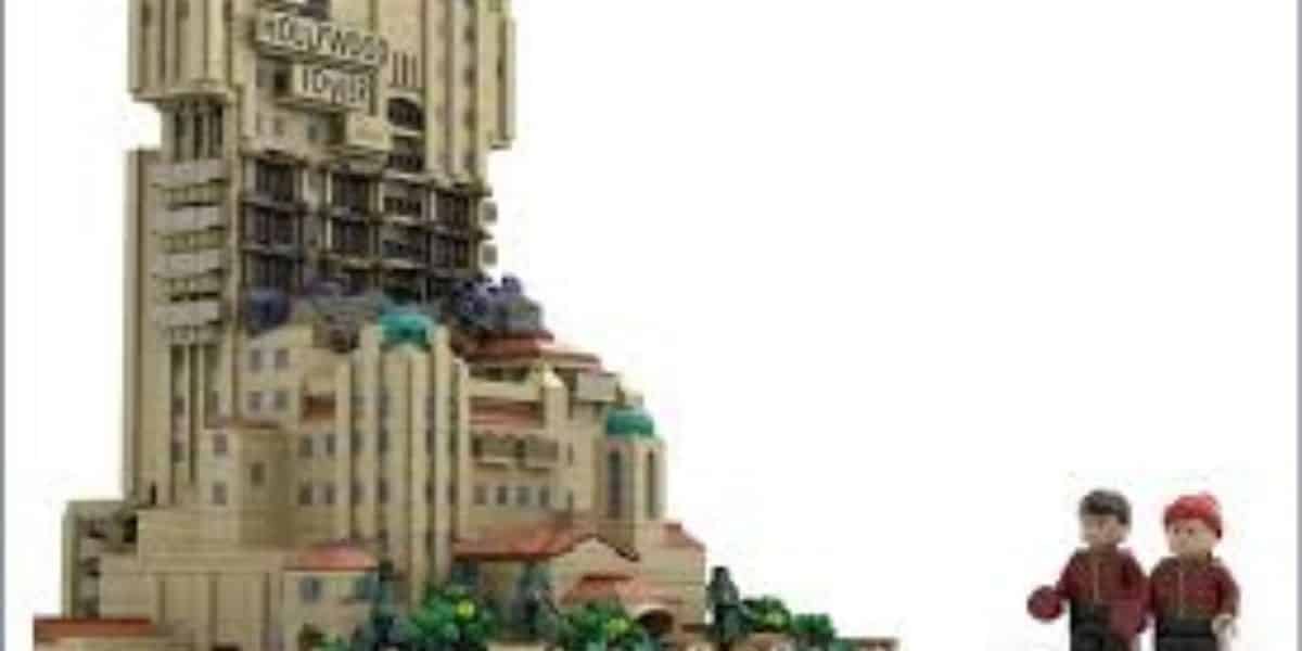 A LEGO model of the Hollywood Tower Hotel with two LEGO minifigures standing nearby on the right, all set against a plain white background.