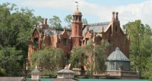 The exterior of the Haunted Mansion at Magic Kingdom Park on a clear day.