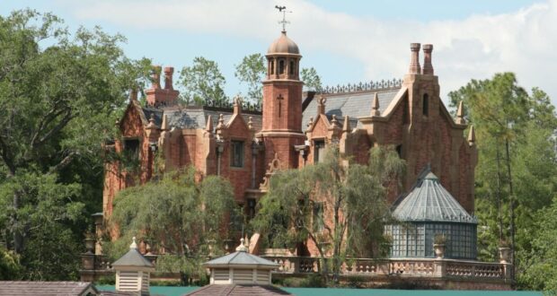 The exterior of the Haunted Mansion at Magic Kingdom Park on a clear day.