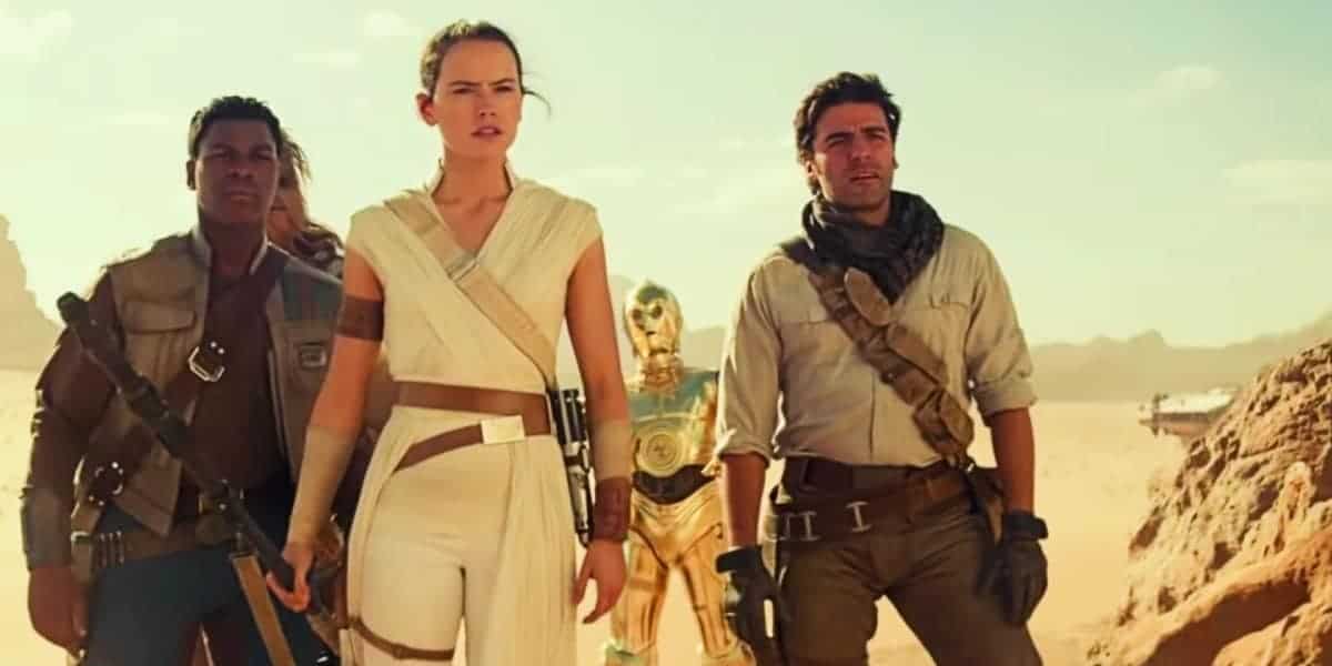 Three people dressed in sci-fi adventure clothing stand confidently in a desert, with a gold humanoid robot and spaceship in the background under a bright sky.