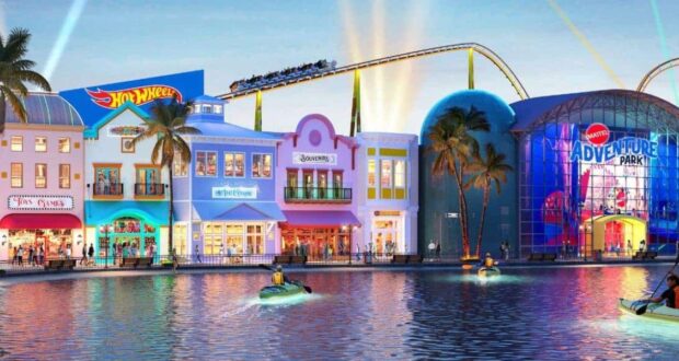 Hot Wheels roller coaster, vibrant shops, and guests enjoying boat rides on the scenic waterway at sunset in Universal Studios.
