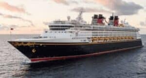 Disney Cruise Line ship gliding across the ocean at sunset, with colorful clouds overhead, promising magical onboard adventures.