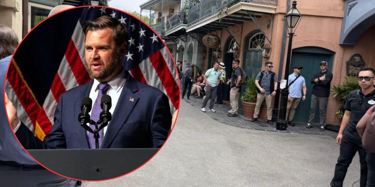 A man addresses an audience, his image over a lively street scene. He's charged after making threats during JD Vance’s Disneyland trip.