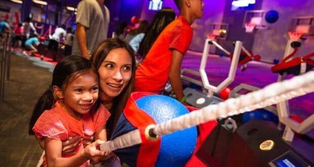 Guests enjoy Disney’s ball-toss arcade game, sharing smiles and excitement in a vibrant theme park arcade atmosphere.