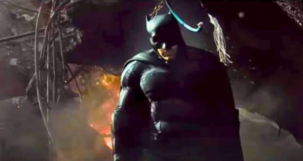 Batman in Gotham City’s shadowy streets, surrounded by smoke and exposed wires for a thrilling DC Universe live show.