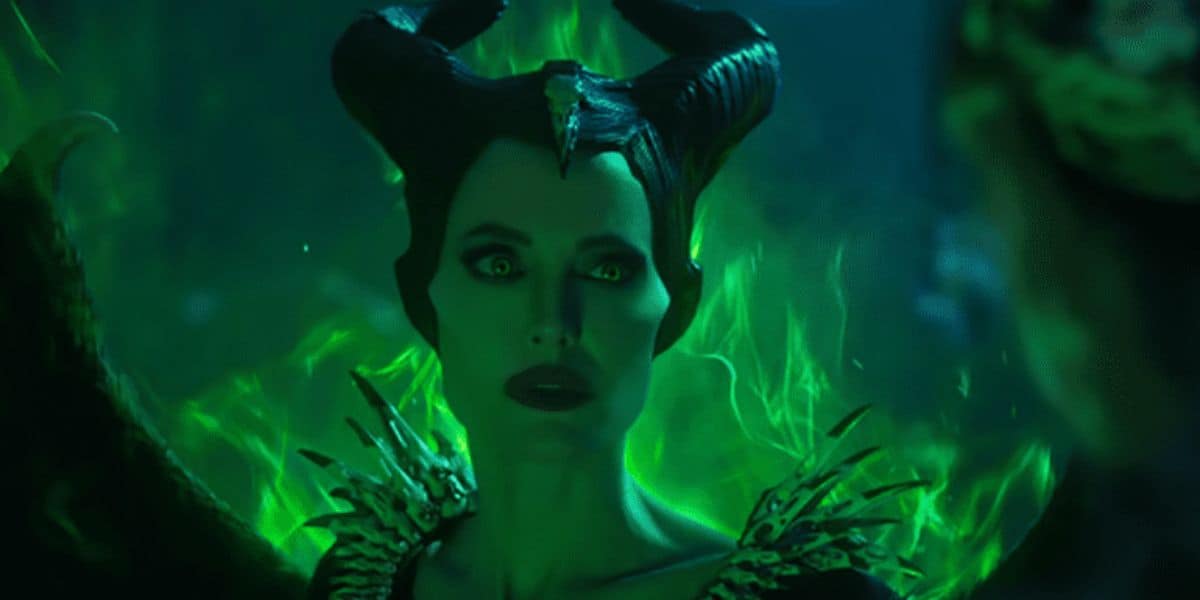 Maleficent stands with her signature black horns and glowing green flames, gazing fiercely like she rules the night.