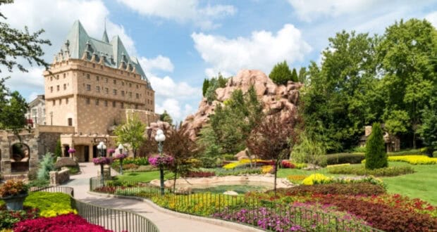 Fairytale stone castle surrounded by vibrant gardens, set against a bright sky—reminiscent of Disney Parks’ magical atmosphere.