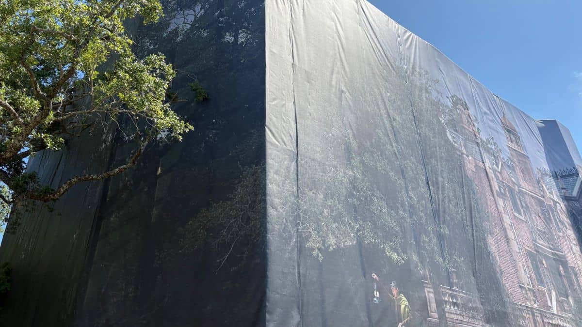Tomorrowland's soon-to-be Viral Icon 2026: a massive structure draped in brick-and-tree design tarp, beside lush greenery.