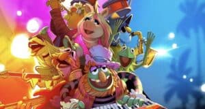 The Muppets perform live on a vibrant stage at a theme park, playing instruments and delighting the audience with their energy.