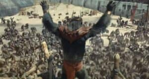 Caesar raises his arms before a gathering of apes in a walled area, recalling a scene from Planet of the Apes.