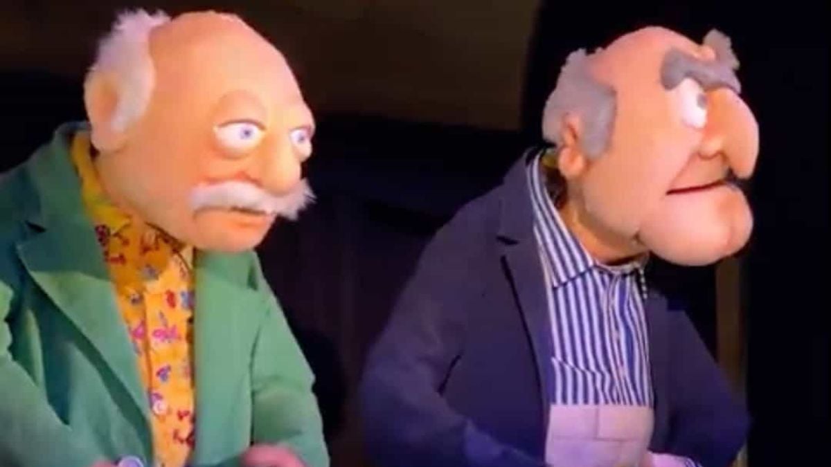 Statler and Waldorf, mustachioed in suits, sit together at Hollywood Studios, eyeing the revamped Muppets coaster.
