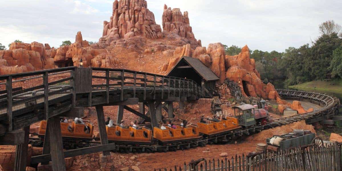 Big Thunder Mountain Railroad train races around rugged peaks at Disneyland, thrilling guests with its wild west adventure.