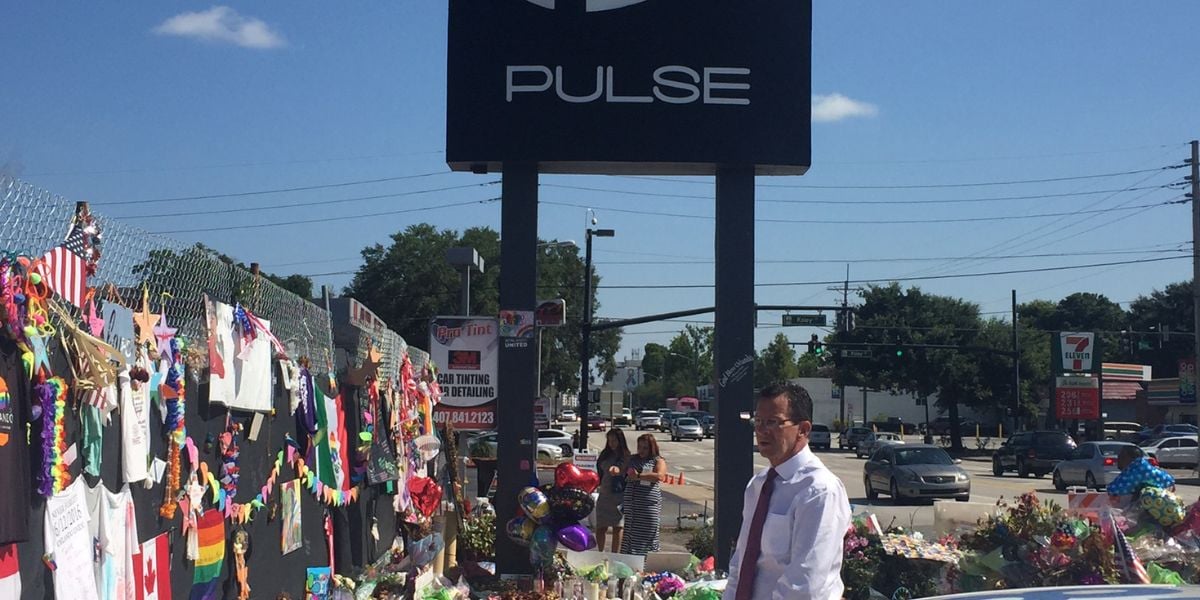 A man stands by a memorial at Pulse nightclub, with flowers and tributes, years after Disney World was linked to the tragedy.