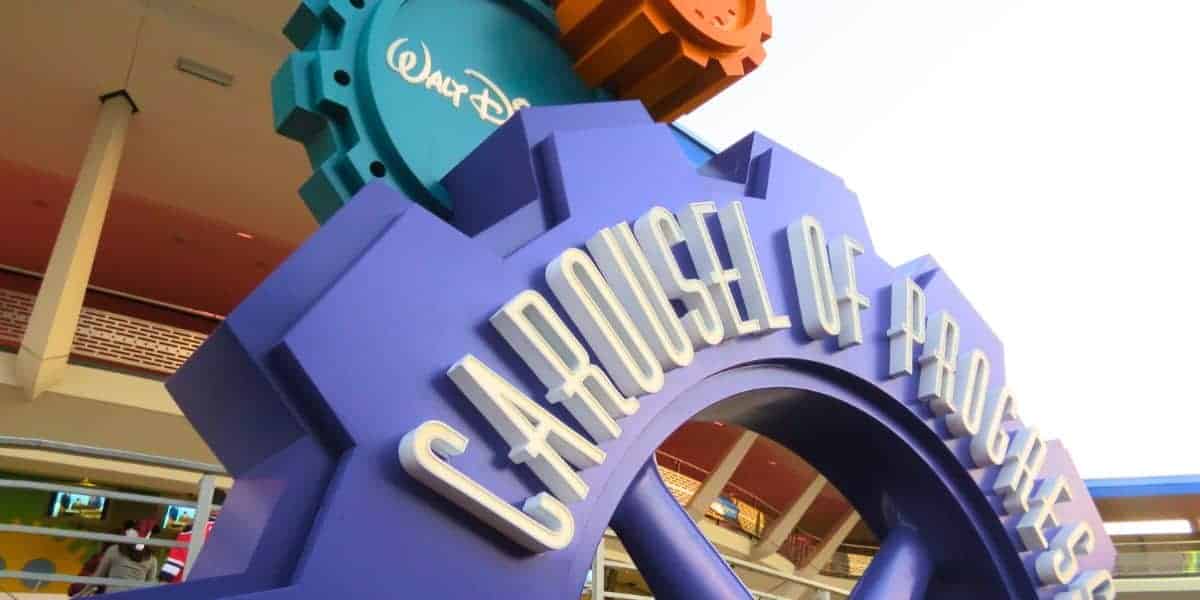 Vibrant Carousel of Progress sign at Disney World, shaped like blue gears, celebrating Walt Disney’s classic attraction.