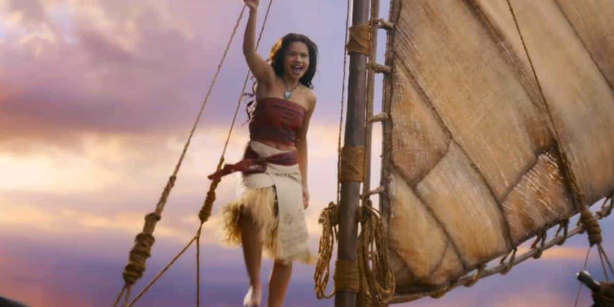 A guest beams with excitement aboard a sailboat, soaking up the magic of a sunset cruise on Disney’s Seven Seas Lagoon.