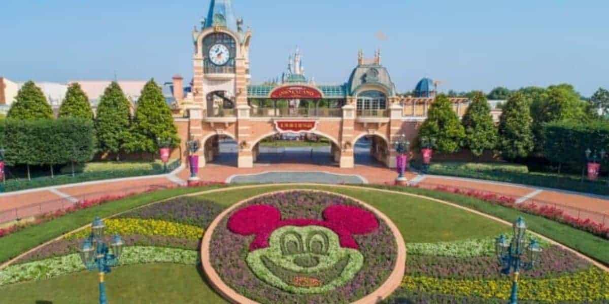 Disneyland’s iconic entrance featuring a vibrant Mickey Mouse floral arrangement and the charming Main Street clock tower.