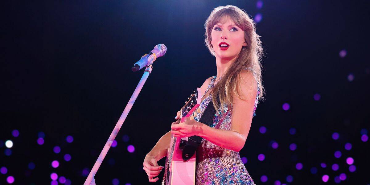 Taylor Swift dazzles in a glittering dress, rocking her guitar on stage amid purple lights as she teases Toy Story 5’s new song.