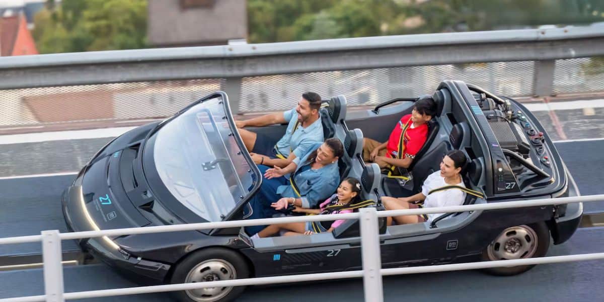 Guests laugh and hold on tight as their black convertible speeds along the Radiator Springs Racers track at Disney California Adventure, soaking up the excitement of the Cars Land attraction.