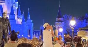 A crowd of guests stands by as a man preaches at Magic Kingdom