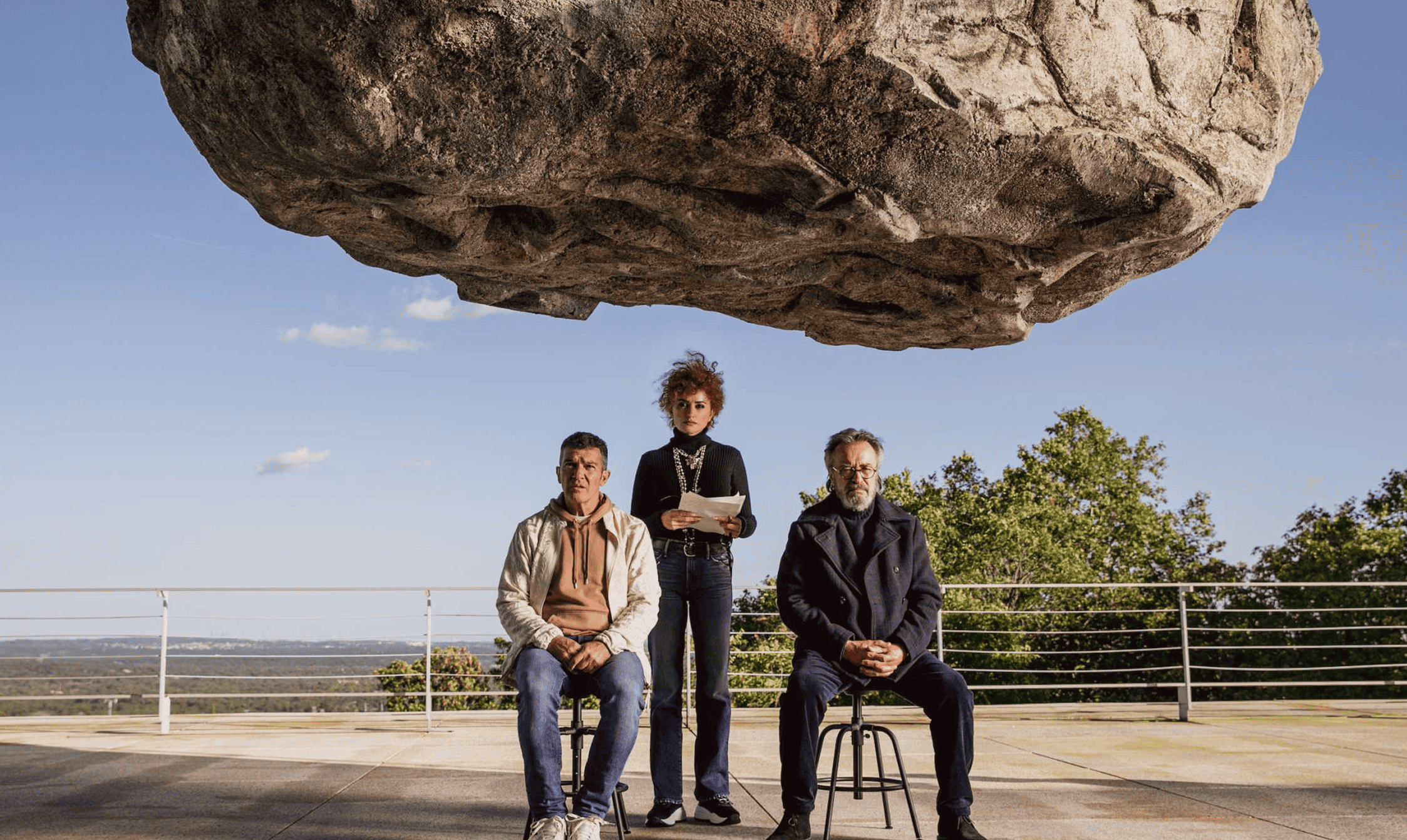Unusual outdoor scene with three people under a massive floating rock, showcasing professional video editing and post-production services at DIVO Post Production.