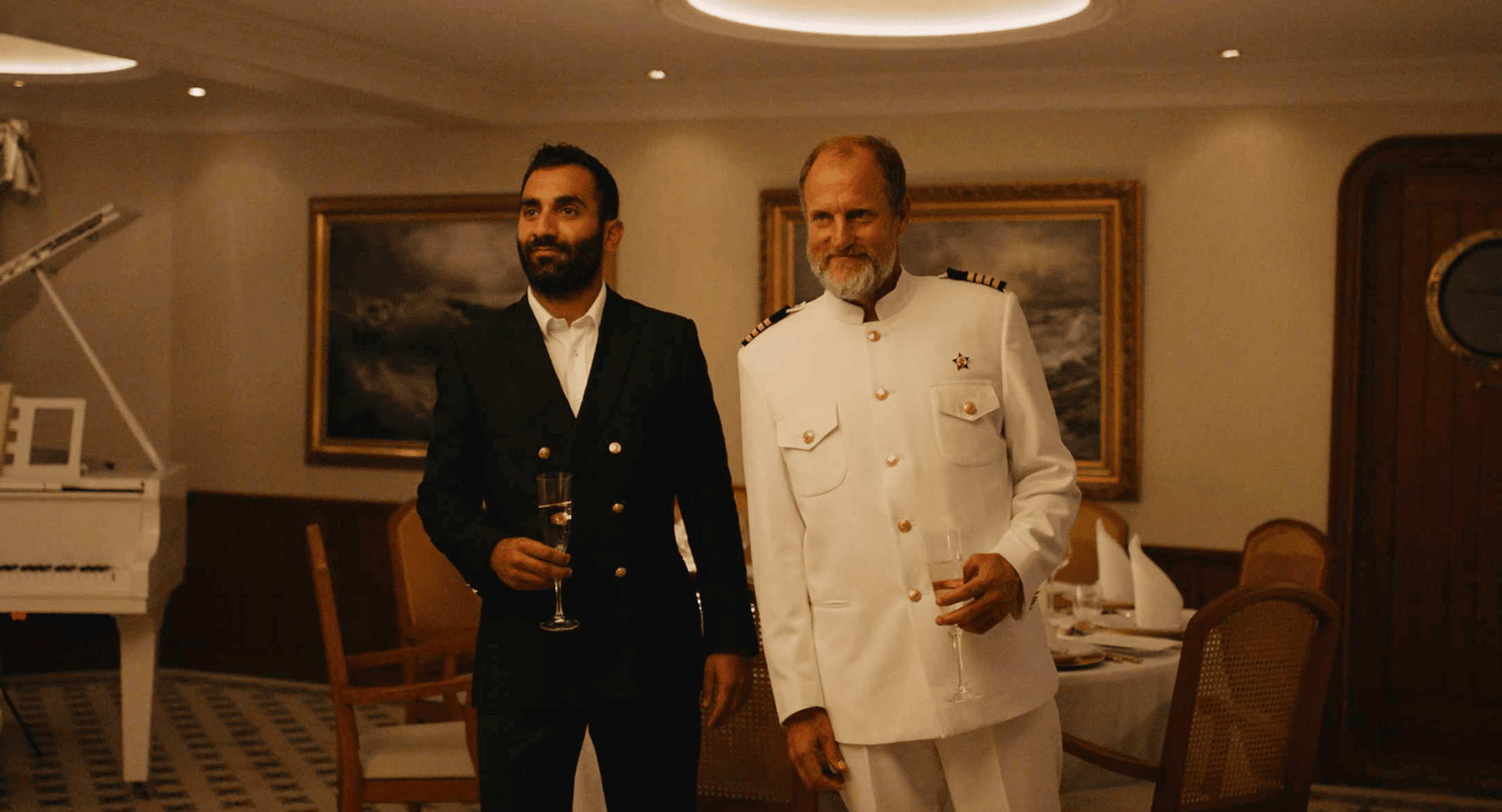 Luxury yacht party celebration with two men in formal attire enjoying drinks in an elegant dining room at DIVO Post Production.