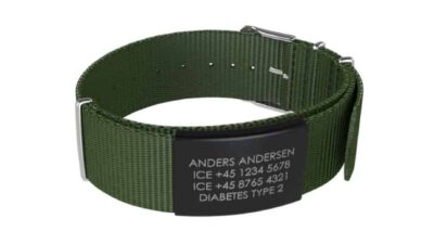 DJUVA Hit komplet armbånd: Grønt nylon ID-armbånd med sort graveret plade, der viser navn, telefonnumre og medicinske oplysninger.